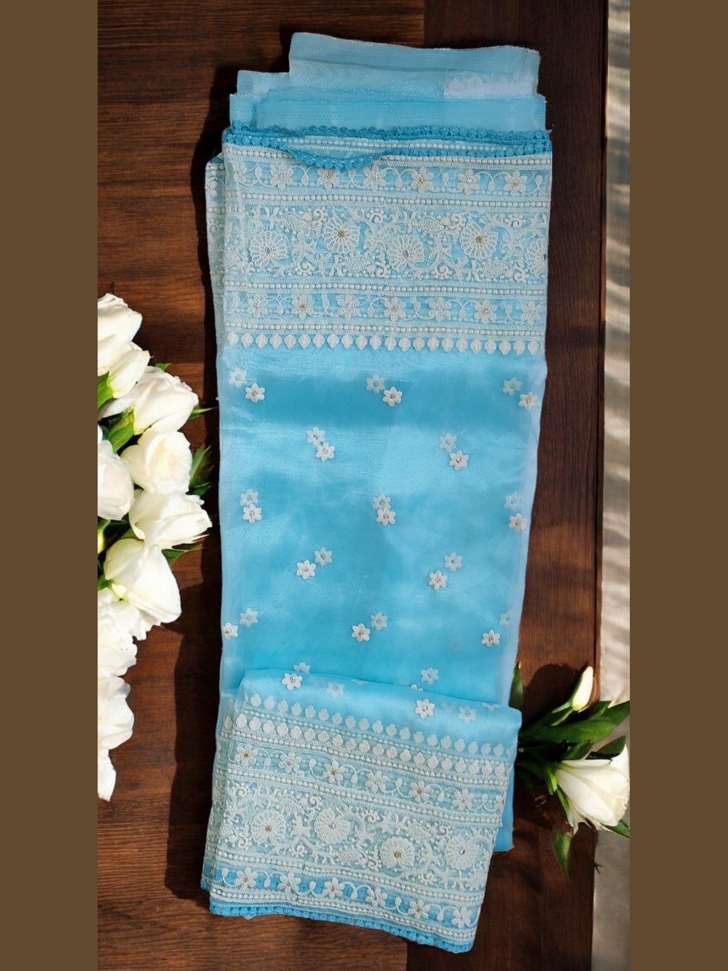 Celestial Cerulean organza silk saree with delicate floral necklace embroidery and sheer frosted finish.