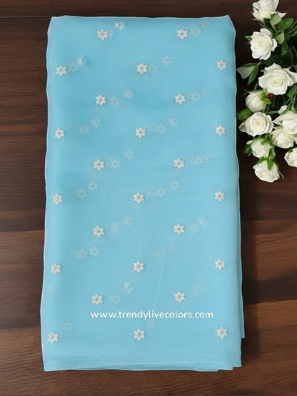 Celestial Cerulean organza silk saree with delicate floral necklace embroidery and sheer frosted finish.