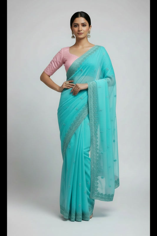 Woman in Seafoam Green Embroidered chiffon Saree and Pink Blouse.