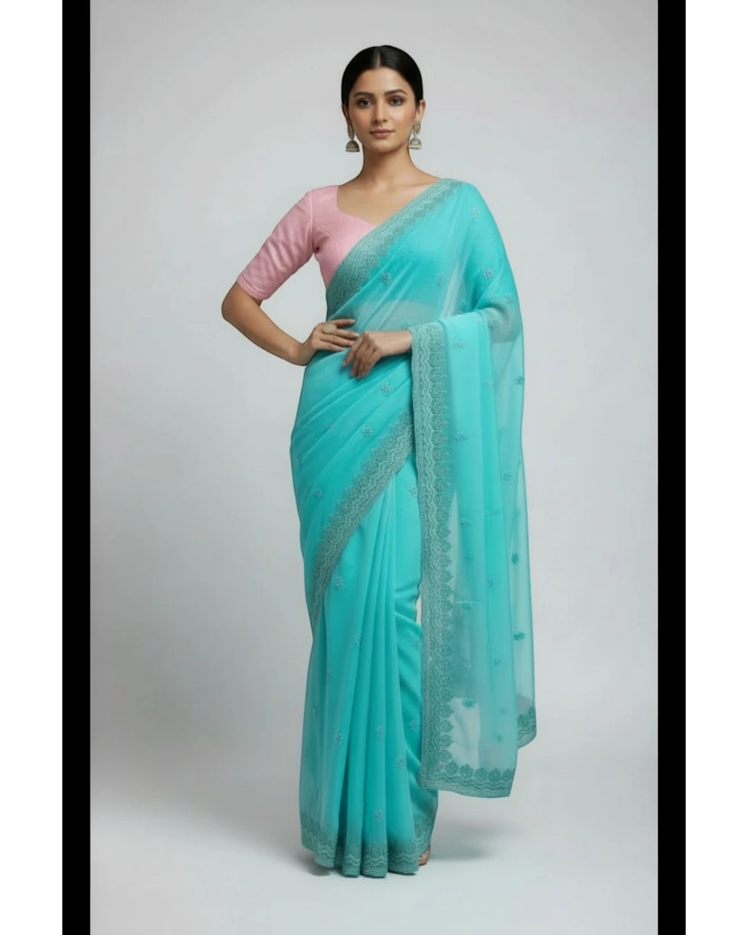 Woman in Seafoam Green Embroidered chiffon Saree and Pink Blouse.